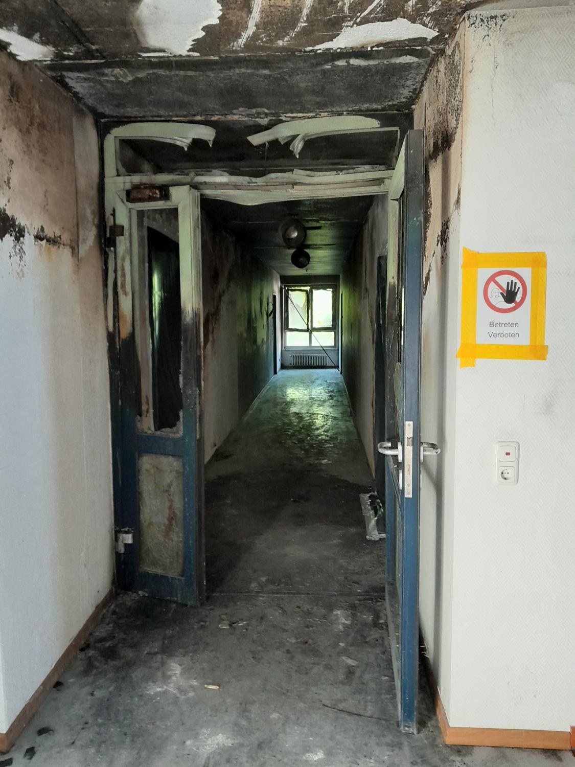 Flur nach einem Brandschaden, verrußte Wände und Decke
